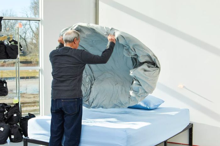 A person carefully arranging the Slumber Cloud Essential Duvet Cover on a neatly made bed