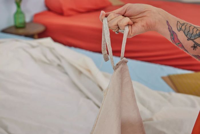 A hand holding the ties on the Southern Living Simplicity Collection Tanner Duvet Cover