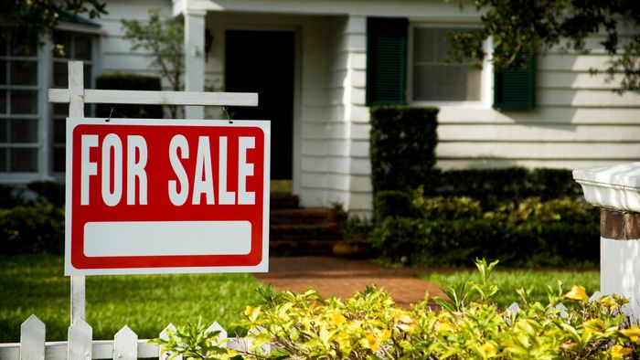 for sale sign in front of a white house with a matching white fence