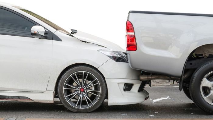 A minor collision between a car and a pickup truck.