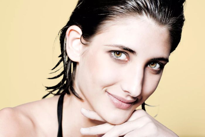 A woman sporting a sleek, wet look with a chic bob hairstyle