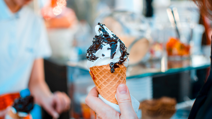 A hand holding an ice cream cone