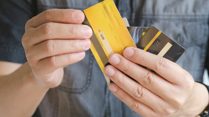Individual holding a stack of credit cards