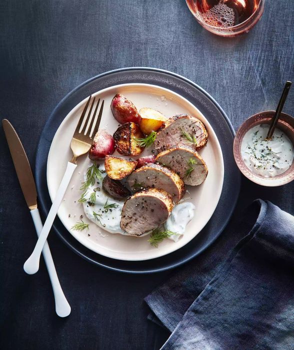 Paprika Pork Tenderloin with Roasted Potatoes and Dill Cream served on a platter