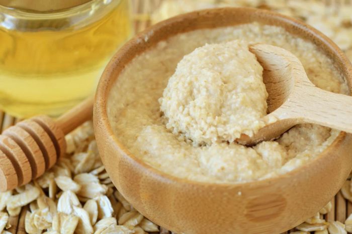 Homemade honey and oatmeal facial mask in a wooden bowl with a spoon