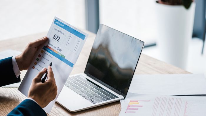 Individual reviewing a credit report on a computer