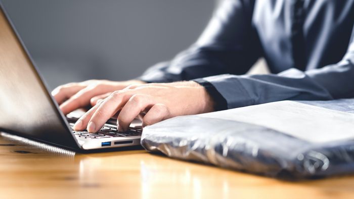 A person with a laptop and package.