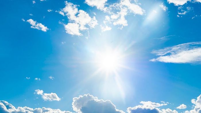 A serene blue sky adorned with fluffy clouds