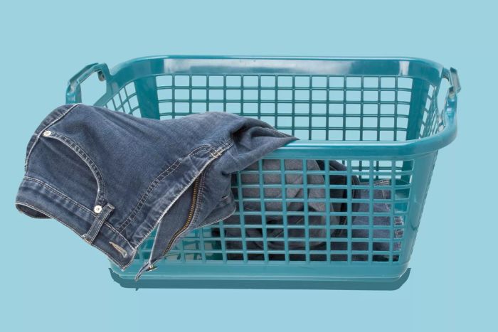 denim pants placed in a laundry hamper