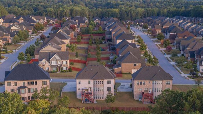 A bird's-eye view of expansive homes nestled in a tree-lined neighborhood.