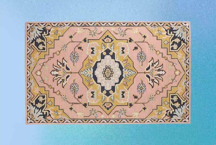 Anthropologie's Tufted Caro Rug displayed on a gradient blue backdrop