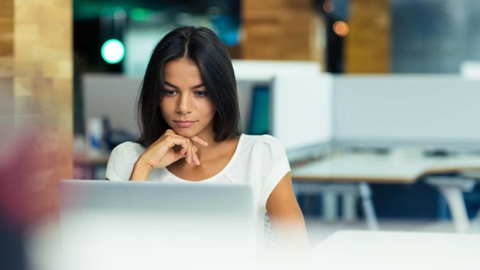 Woman examining a laptop screen
