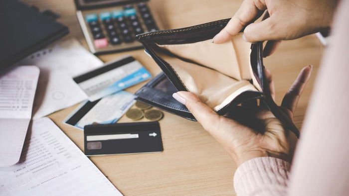 A woman with an empty wallet in her hands