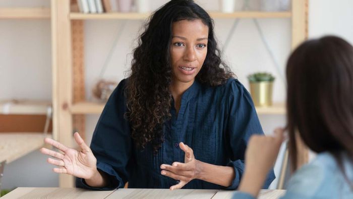 A female manager engaging in a serious discussion with an employee.