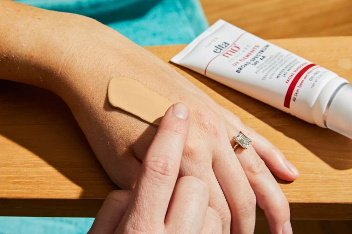 A person applying EltaMD UV Elements Tinted Broad-Spectrum SPF 44 to the back of their hand