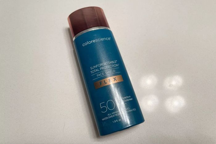 A bottle of Colorescience Sunforgettable Total Protection Face Shield Flex SPF 50 placed on a counter