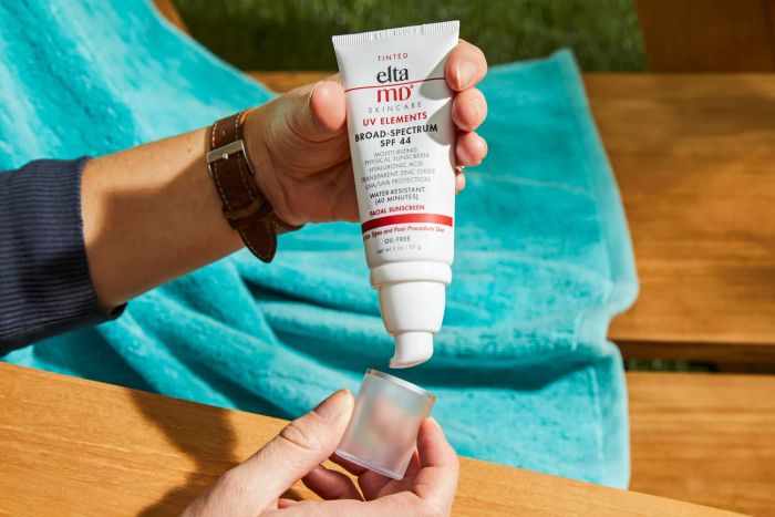 A person removing the cap from EltaMD UV Elements Tinted Broad-Spectrum SPF 44