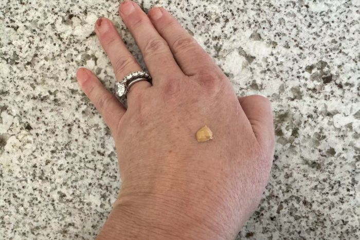 A drop of Eucerin Age Defense Face Sunscreen Tinted Lotion SPF 50 on the back of a hand