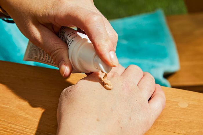 A person applying EltaMD UV Elements Tinted Broad-Spectrum SPF 44 to the back of their hand