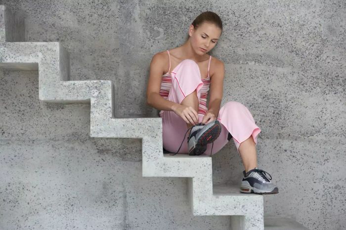 Stair exercises to try at home – woman taking a break on the stairs