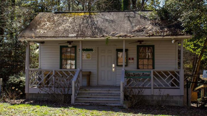 A dilapidated and abandoned home seen from the front.