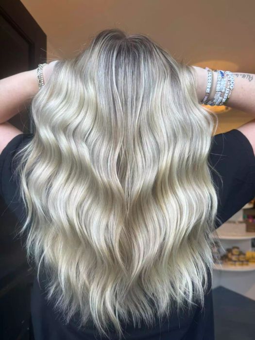 Utah curls on long blonde hair create a soft, effortless look.