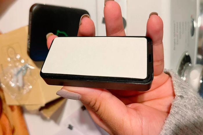 A person holding the base of an Avantek Wireless Doorbell
