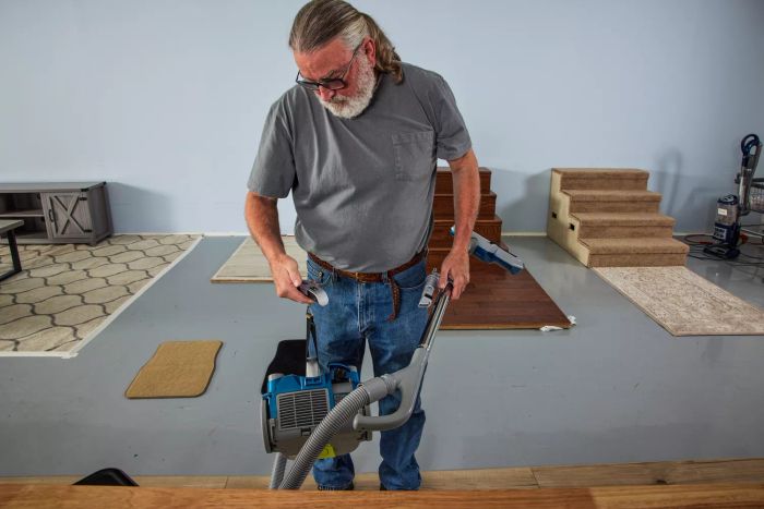 A person is using the Kenmore Compact Bagless Canister Vacuum to clean.