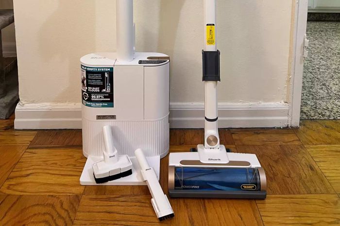 Shark WS642AE Wandvac Cordless Stick Vacuum with Self-Empty Charging Base and attachments shown on a wood floor