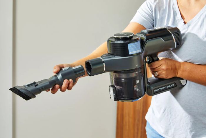 A hand attaching the brush accessory to the Levoit VortexIQ 40 Cordless Stick Vacuum