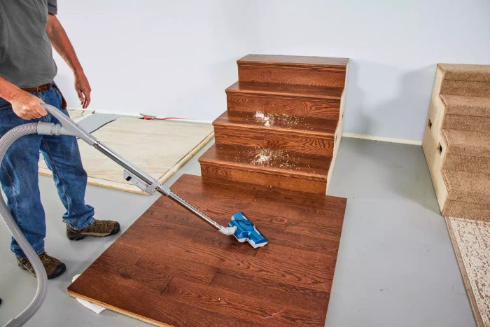 A person is cleaning a wooden floor with the Kenmore Compact Bagless Canister Vacuum.