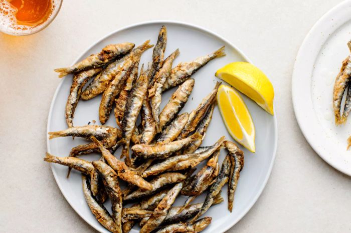 Classic Fried Whitebait (Fried Tiny Fish), fried fish and lemon wedges on a plate