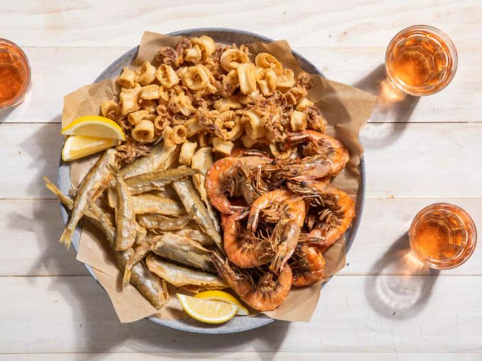 A generous platter of fritto misto di mare, featuring fried shrimp, squid, and smelt.