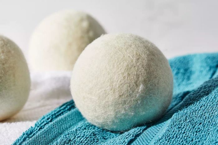 A close-up shot of the Handy Laundry Wool Dryer Balls resting on top of a towel