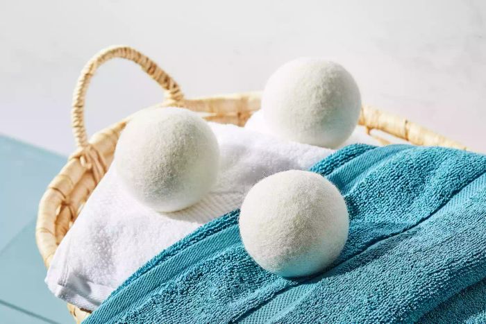 Smart Sheep Wool Dryer Balls resting on top of towels inside a basket.