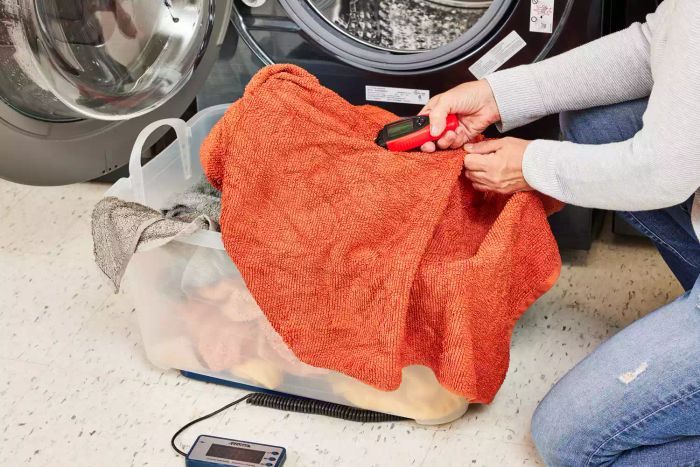 A person feeling a towel straight out of the dryer that was treated with the Grove Co. Wool Dryer Balls & Eucalyptus Essential Oil Set.