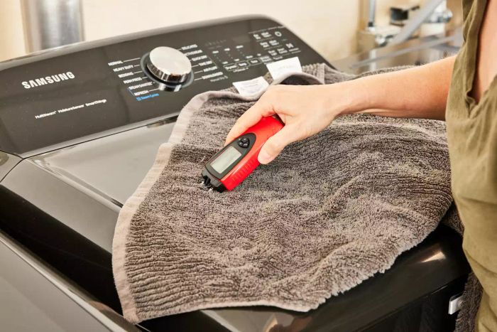 A person using a device on a towel after it had been inside a dryer with Nellie's Dryerballs.