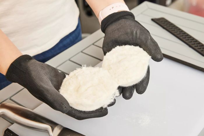 An individual cutting the Handy Laundry Wool Dryer Ball in half