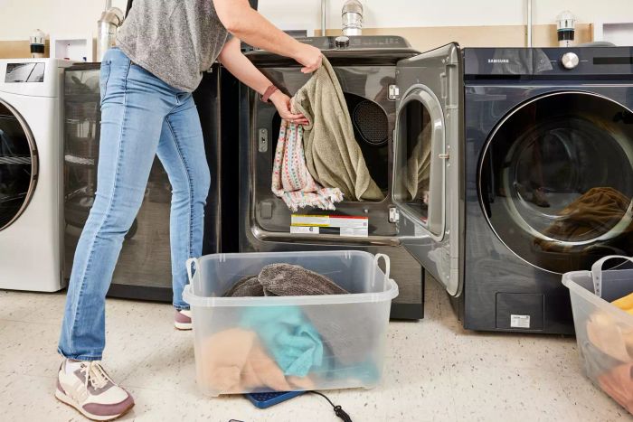 A person pulling clothes from a dryer that has the World Market Hedgehog Dryer Balls inside