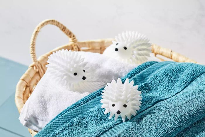 World Market's Hedgehog Dryer Balls resting on top of laundry inside a woven basket.