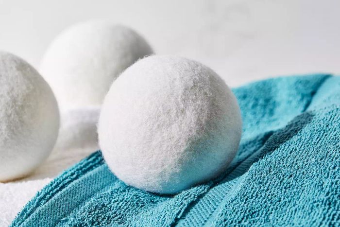 A close-up shot of the Everspring 100% New Zealand Wool Dryer Balls resting on a stack of towels