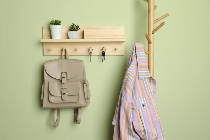 A wooden key hanger on a light green wall
