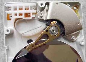 The arm and motor of an exposed hard disk drive.