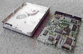 Two internal halves of a hard disk drive, showing the electronics board.