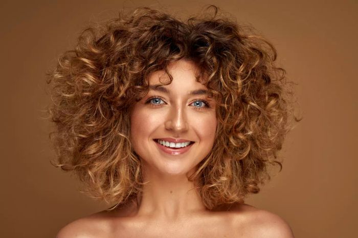 A smiling young woman with natural curls