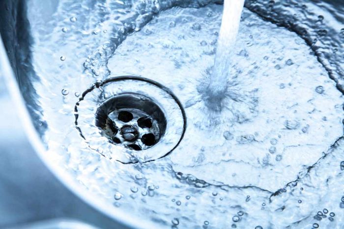 Water flowing from a faucet into a metal sink