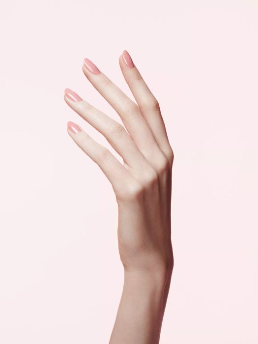 A raised hand featuring a stylish pink gel manicure.