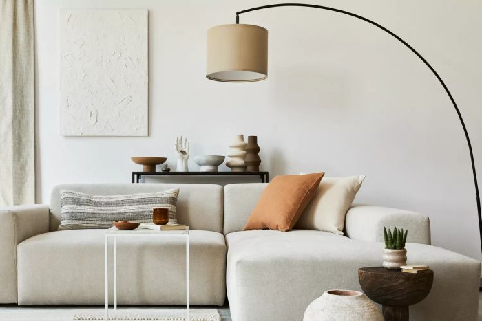 A stylish arrangement of a cozy living room, featuring a mock-up poster frame, a modern sofa, a coffee table, textiles, and personal decor accents. A perfect example of Scandinavian classic style.