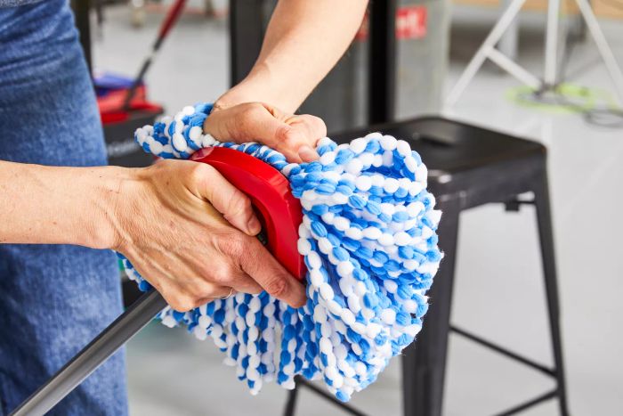 A person adjusts the O-Cedar EasyWring RinseClean Spin Mop & Bucket System mop