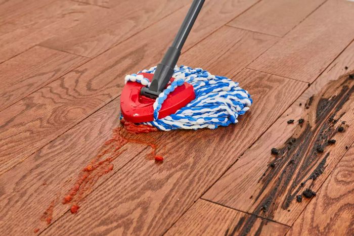 The O-Cedar EasyWring RinseClean Spin Mop & Bucket System is used to clean food off a wood floor
